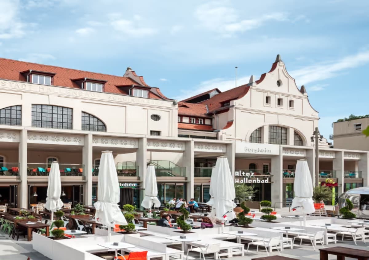 Terrasse des Alten Hallenbads in Heidelberg mit weißen Sonnenschirmen
